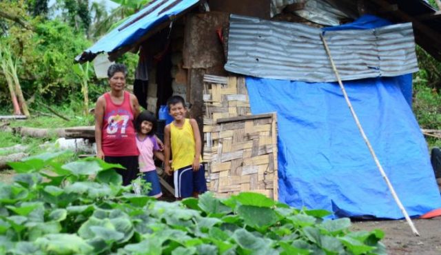 Norma and her children live inside a neighbour’s house that is drenched everytime it rains. Their home was destroyed during Typhoon Haiyan. Since the storm, the children and their mother have been squatting in a neighbour’s house that is covered by a worn-out tarpaulin. Now Norma’s family will be receiving shelter material from World Vision to help them recover. PHOTO: Mark Nonkes/Worl