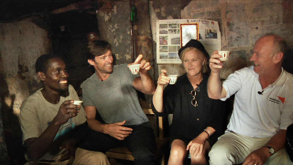 Dukale, Hugh, Deb, and Tim drink coffee in Dukale's hut.